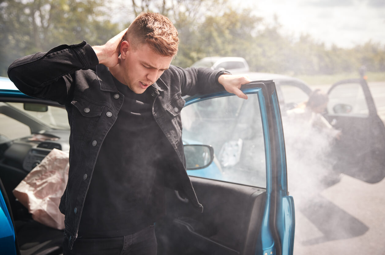 Man holding his head in pain after being in a car accident.