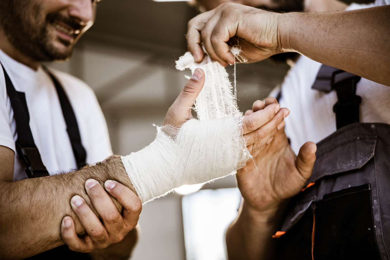 Burn Injuries co worker wraps mans hand with ace bandage after burn accident